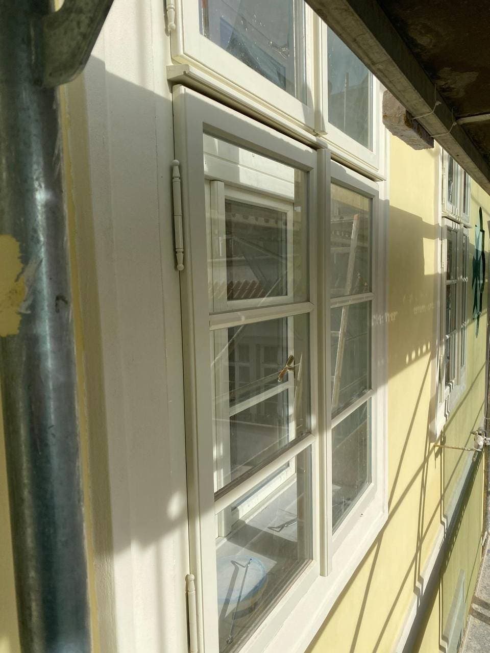 Špaletové okno v obnovené fasádě s malovaným dekorem