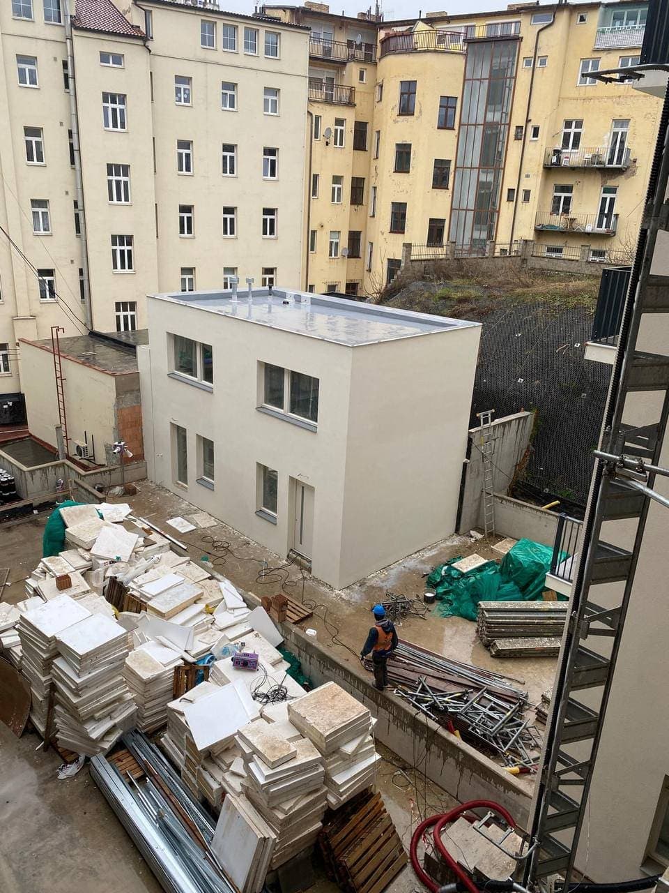 Dvorní přístavba s dokončenou fasádou, kolem ještě probíhá stavba