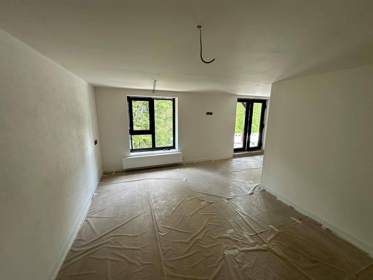 Obývací pokoj po nových omítkách a malbě, podlaha ještě zakrytá