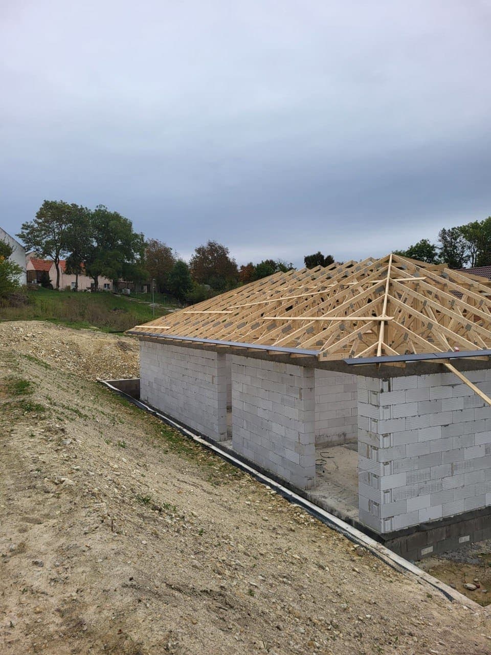 Hrubá stavba bungalovu s osazeným vazníkovým krovem